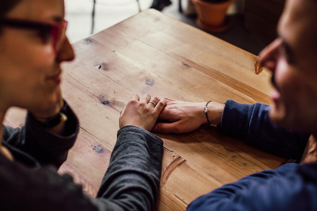  two people at a table talking about getting help for someone who doesn’t want it